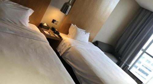 a hotel room with two beds and a window at The Art Hotel in Shenzhen