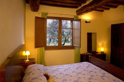 a bedroom with a bed and a window at Casale Rosanna in San Gimignano