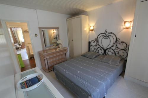 奧雷龍聖喬治的住宿－La Villa Oleron，一间卧室配有一张大床和镜子
