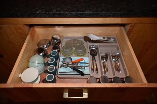 a drawer with utensils in a wooden box at AVY Abode - 3bhk Farm Stay, Private Pool in Moinabad in Venkatāpur