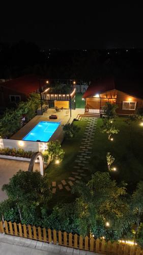 a backyard with a swimming pool at night at AVY Abode - 3bhk Farm Stay, Private Pool in Moinabad in Venkatāpur