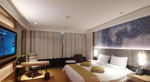 a hotel room with a bed and a flat screen tv at GreenTree Inn Taiyuan PinGYAng Road Business Hotel in Taiyuan