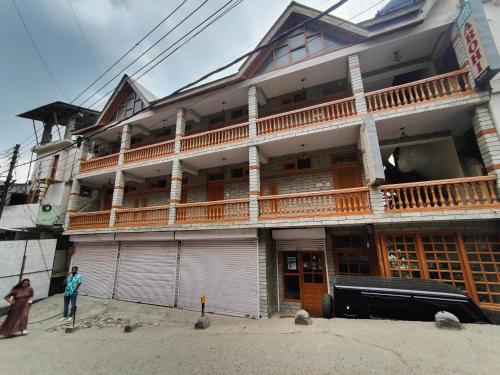 a man standing in front of a building at Hotel Arohi in Vashisht