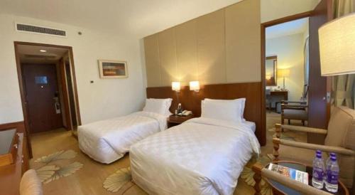 a hotel room with two beds in a room at Jianguo Garden Hotel in Beijing