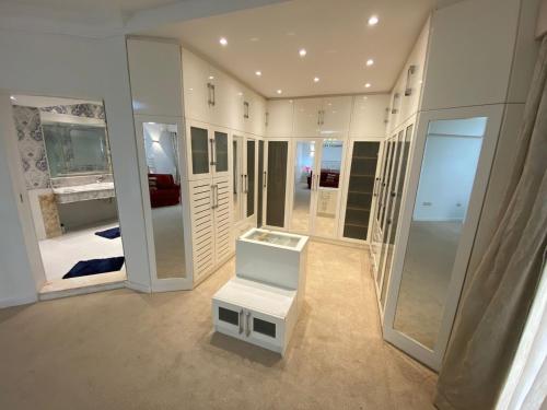 un dressing avec des miroirs et un tabouret blanc dans l'établissement فيلا منفصله بحمام سباحه فى مدينتى, à Madinaty