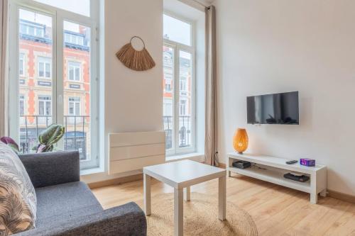 un salon avec un canapé et une télévision dans l'établissement 1 bedroom apartment near Catholic University, à Lille