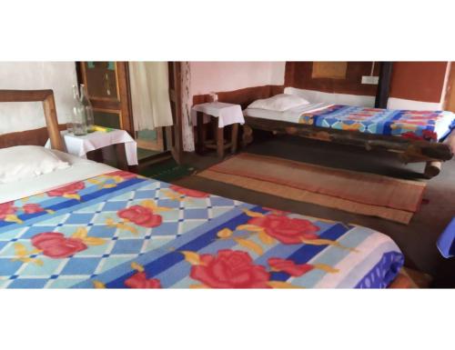 a bedroom with two beds with flowers on it at Desia Duduma, Puri 