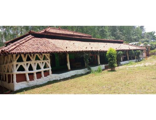 a small house with a thatched roof and a yard at Desia Duduma, Puri 