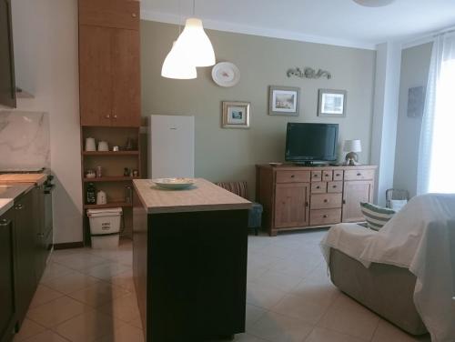 eine Küche mit einer Theke und einen TV in einem Zimmer in der Unterkunft CASA L'UNICORNO con giardino privato in Levanto