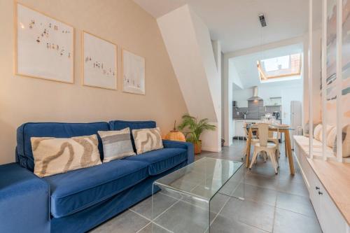 un salon avec un canapé bleu et une table dans l'établissement Maison 3 chambres, parking gratuit & proche métro, à Croix