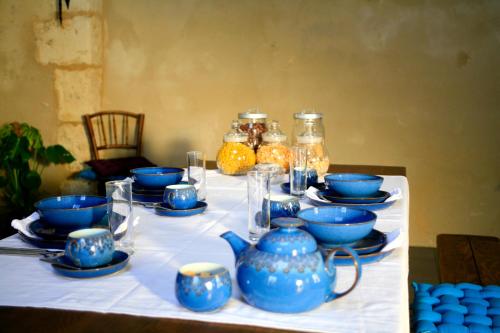 un tavolo con porcellana blu su una tovaglia bianca di Le Chaton Rouge a Saint-Pierre-du-Lorouër
