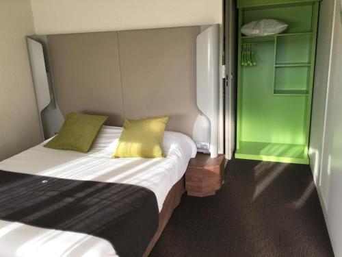a bedroom with two beds and a green closet at Campanile Le Havre Nord - Montivilliers in Montivilliers
