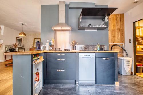 a kitchen with blue cabinets and a counter top at Les apparts du TRECH in Tulle