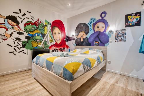 a bedroom with a bed with cartoon characters on the wall at Les apparts du TRECH in Tulle