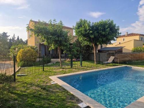 une piscine dans la cour d'une maison dans l'établissement Villa Beau Soleil Piscine Jardin Parking, à LʼIsle-sur-la-Sorgue