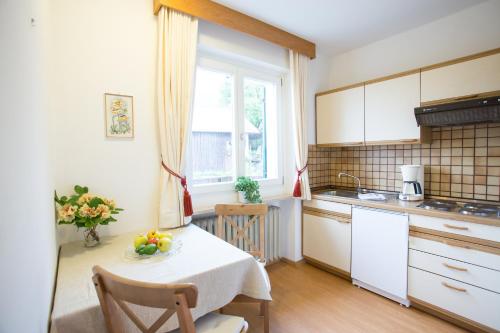 a kitchen with a table with a bowl of fruit on it at Garni Pluner in Schenna