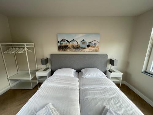 a bedroom with a bed and a painting on the wall at Familie appartement Katwijk aan zee 1 in Katwijk aan Zee