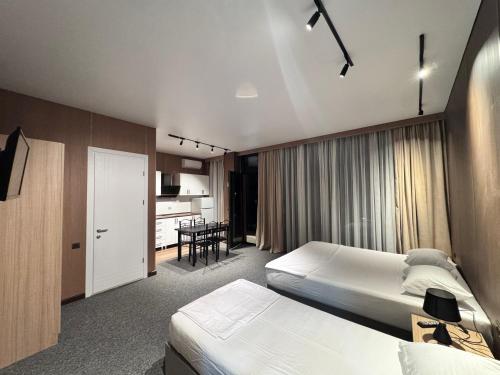 a hotel room with two beds and a kitchen at Nina two in K'obulet'i