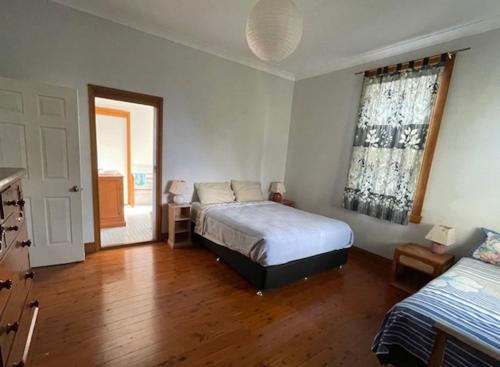 a bedroom with a bed and a window at Cliff Cottage - Noraville in Norah Head