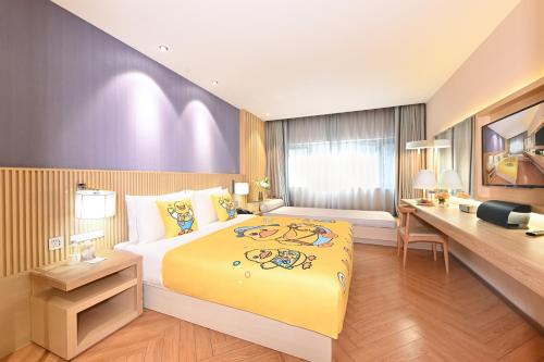 a hotel room with a large bed and a desk at Beijing Nanluoguxiang Orange Crystal Hotel in Beijing