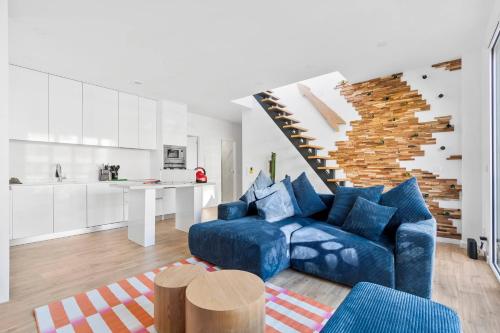 un salon avec un canapé bleu et une cuisine dans l'établissement Rooftop porte de Paris - Spa - Cinema - Pergola, à Chaville