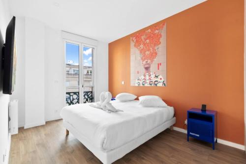 una camera con un letto bianco e una parete arancione di Rooftop porte de Paris - Spa - Cinema - Pergola a Ville-dʼAvray