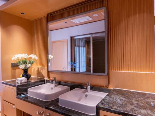 Un baño con dos lavabos y un espejo grande. en Tsuru Yoshikawa Onsen, en Manazuru