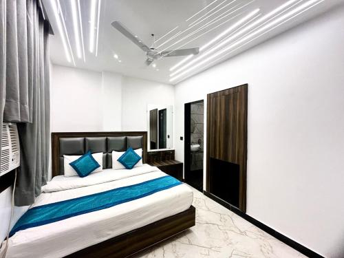 a bedroom with a large bed with blue pillows at Hotel Delhi Empire Dx in New Delhi
