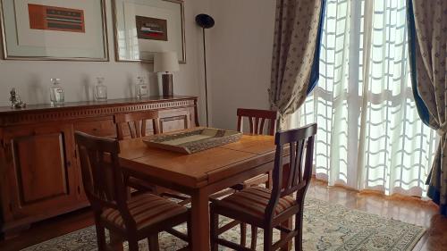 a dining room table with chairs and a table with a laptop on it at Pit stop in Villa nel Verde a Roma-Aeroporto di Ciampino in Rome