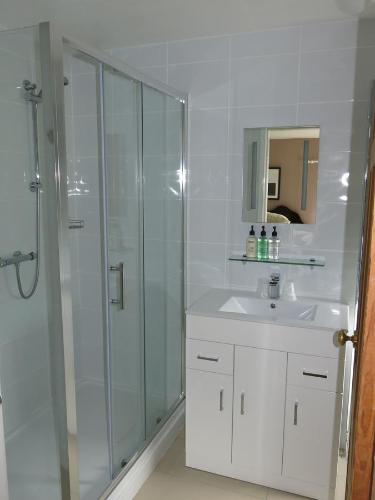 a white bathroom with a shower and a sink at Broadwell Guest House in Meriden