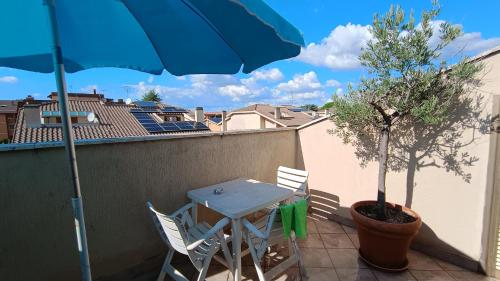 a table and chairs on a balcony with an umbrella at Pit stop in Villa nel Verde a Roma-Aeroporto di Ciampino in Rome