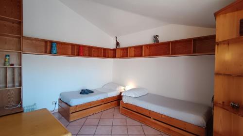 two beds in a small room with wooden cabinets at Pit stop in Villa nel Verde a Roma-Aeroporto di Ciampino in Rome