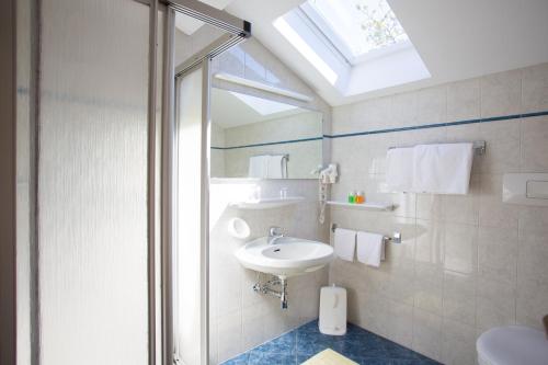 a bathroom with a sink and a glass shower at Garni Pluner in Schenna