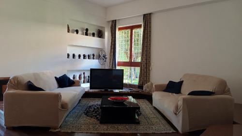 a living room with two chairs and a television at Pit stop in Villa nel Verde a Roma-Aeroporto di Ciampino in Rome