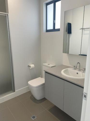 a white bathroom with a toilet and a sink at Ningaloo Coral Bay – Bayview in Coral Bay