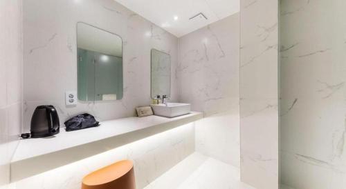 a white bathroom with a sink and a mirror at Bobo Hotel Hongdae in Seoul