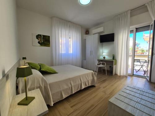 a bedroom with a bed and a desk and a window at B&B testa di Moro in Giarre
