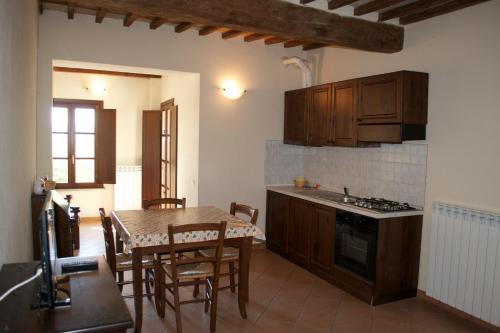 Residence Giuly Rosselmini في Pieve di Santa Luce: مطبخ وغرفة طعام مع طاولة وكراسي