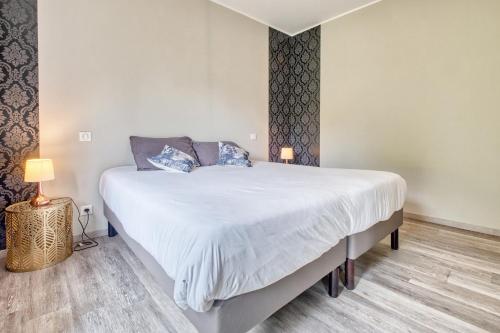 a bedroom with a large white bed with two pillows at La Chanconie in Chez le Turc