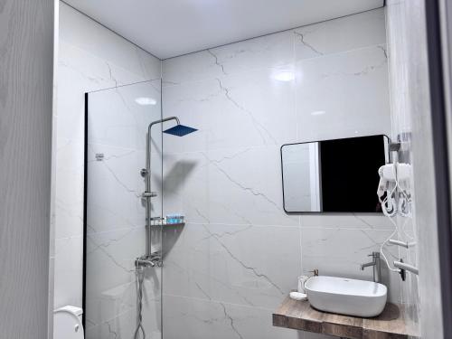a bathroom with a shower with a sink and a mirror at Nina two in K'obulet'i