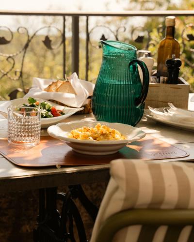 a table with plates of food and a green vase at Klinci Village Resort in Lustica