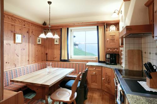 a kitchen with a wooden table and a window at DieAussicht - Refugium am Berg in Hippach