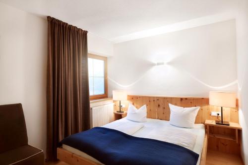 a bedroom with a bed with a blue blanket at DieAussicht - Refugium am Berg in Hippach