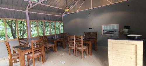 a dining room with wooden tables and chairs at whistling woods resort in Kailāna