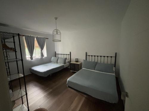 a bedroom with two beds and a book shelf at CASERIO LA SEVILLANA in Baeza