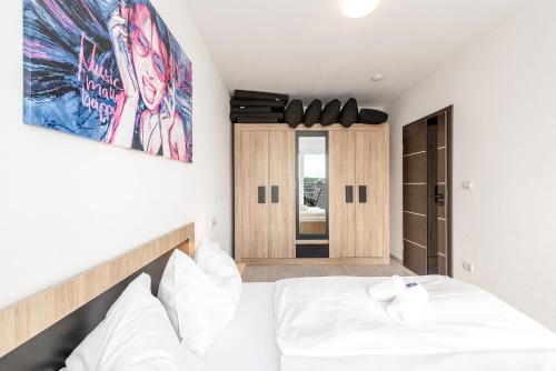 a bedroom with a white bed and a mirror at Dreamhouse 1 Apartment - by myNests in Gröbming
