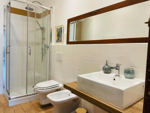 Un baño con lavabo, inodoro y ducha. en Veranda Liberty, luxury apartment, en La Spezia