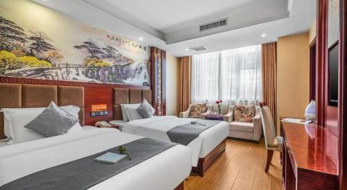 a hotel room with two beds and a couch at GreenTree Inn Kunming Baiyun Road Tongde Plaza Branch in Kunming