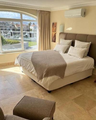 a bedroom with a large bed and a window at Krystal Beach Hotel in Gordonʼs Bay