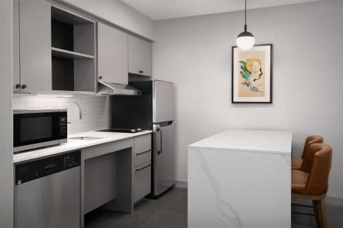 a kitchen with a white counter and a refrigerator at Homewood Suites by Hilton Vancouver / Portland in Vancouver